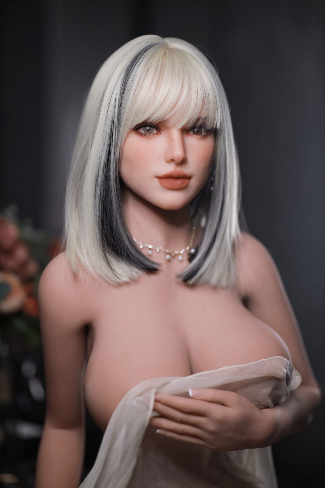 DutchDoll Tiana 159 cm lalka erotyczna z blond włosami z czarnym pasemkiem, grzywką i naszyjnikiem, portret