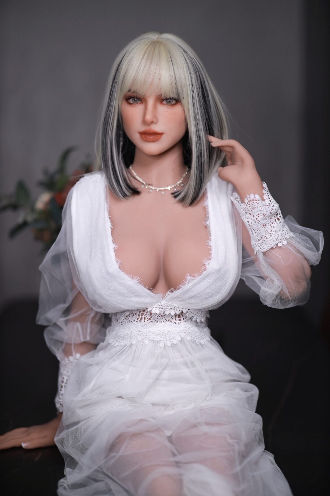 DutchDoll Tiana 159cm lalka erotyczna siedząca w białej koronkowej sukience z głębokim dekoltem i blond włosami z grzywką