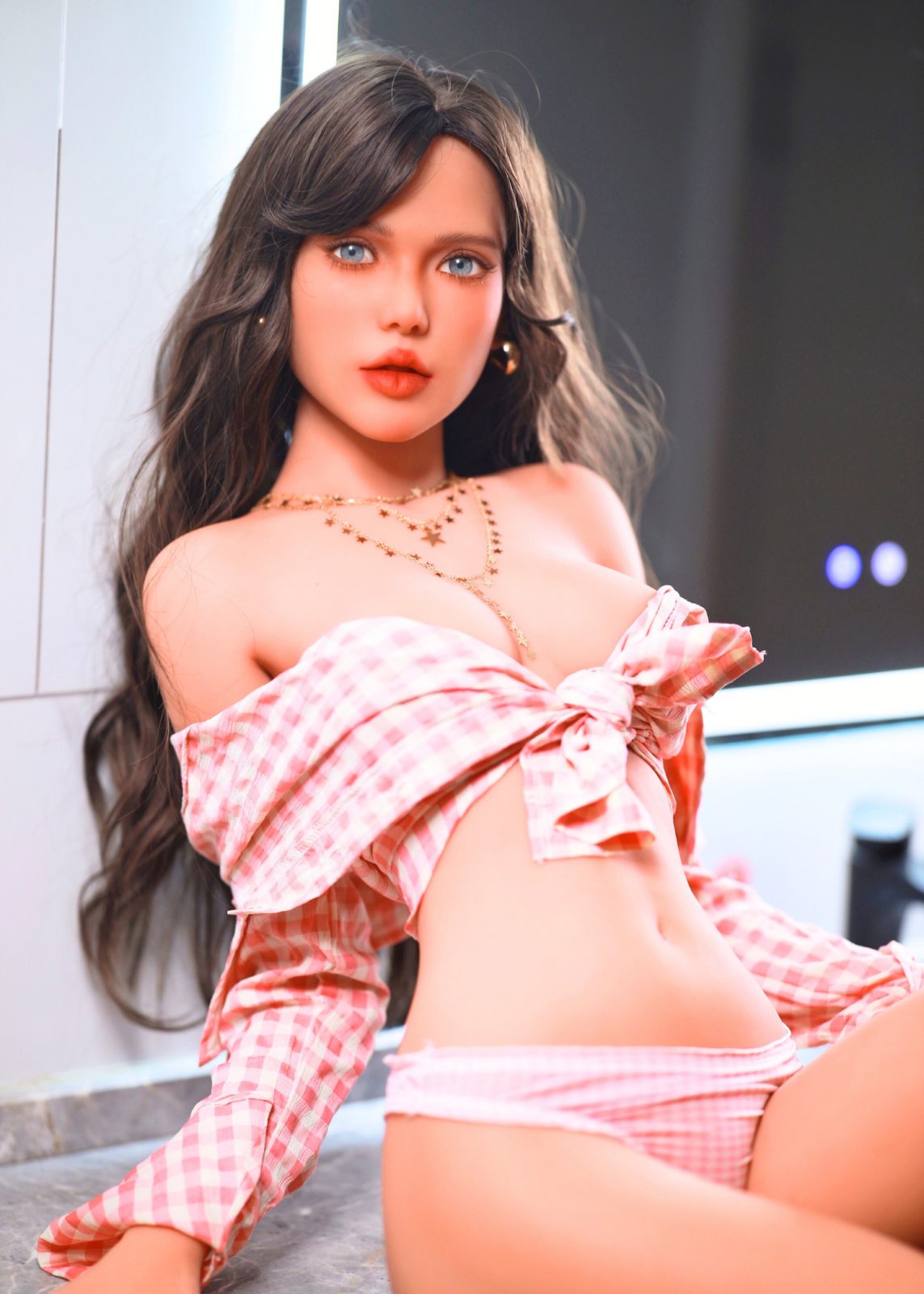 Blazedoll Zoey 157 cm lalka erotyczna siedząca w kratkowanym topie z odkrytymi ramionami i długimi brązowymi włosami