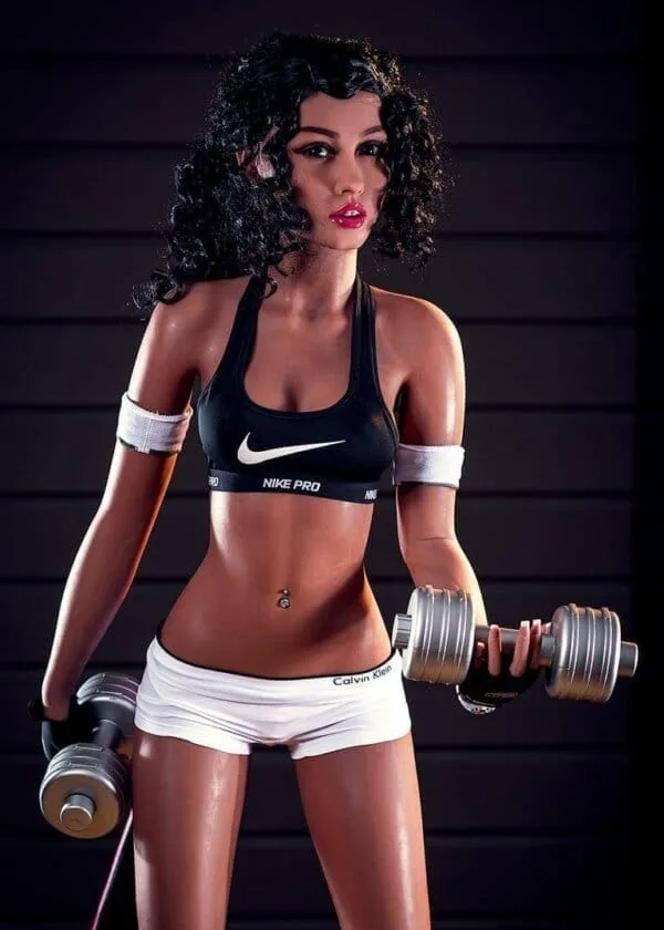 Sex Doll, dunkles lockiges Haar, schwarzer Sport-BH, Bauchnabelpiercing, Gewichte in den Händen, kurze weiße Shorts.