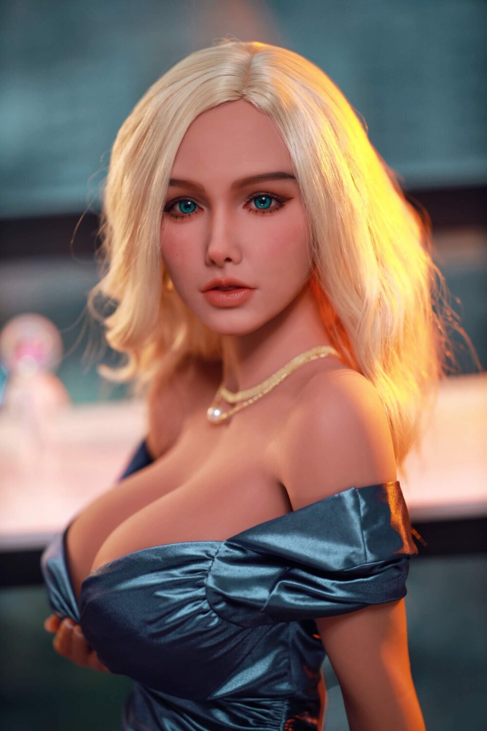 Sex Doll blondynka z niebieskim ioczami, niebieska sukienka, duże piersi, złoty naszyjnik.