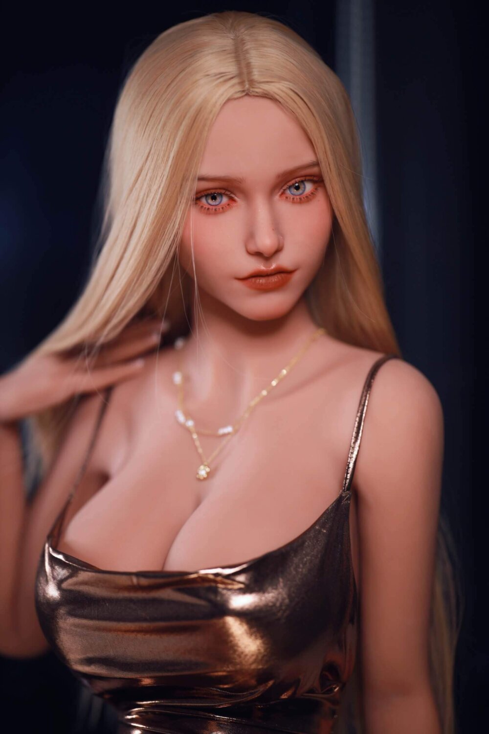 Sex Doll blondynka, duże niebieskie oczy, ręka na ramieniu, złote naszyjniki, duże piersi w brązowej sukience