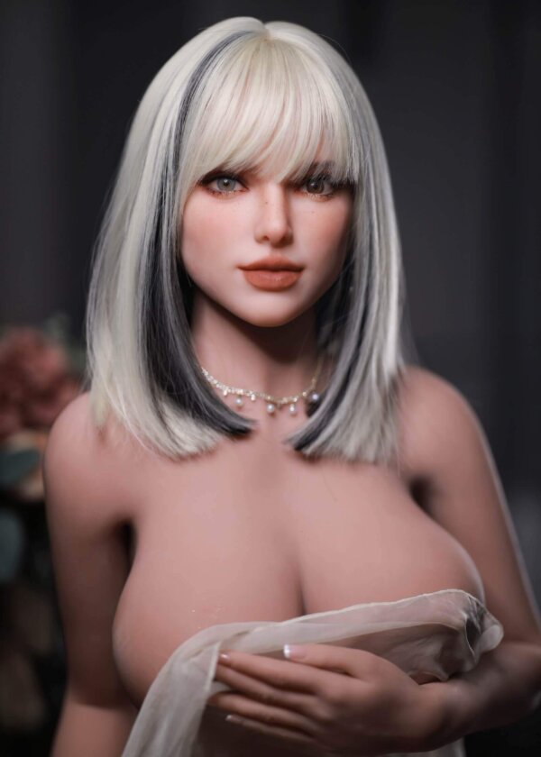SexDoll krótkie blond włosy z czarnymi akcentami, dwa różne kolory oczy, duże usta, duże piersi przykryte materiałem, srebrny naszyjnik